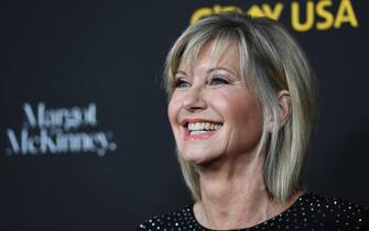 (FILES) In this file photo taken on January 27, 2018 Olivia Newton-John arrives for G'Day USA Los Angeles Black Tie Gala in Los Angeles California. - Australian singer Olivia Newton-John, who gained worldwide fame as high-school sweetheart Sandy in the hit musical movie "Grease," died on August 8, 2022, her family said. She was 73. The entertainer, whose career spanned more than five decades, devoted much of her time and celebrity to charities after being diagnosed with breast cancer in 1992. (Photo by Robyn Beck / AFP)