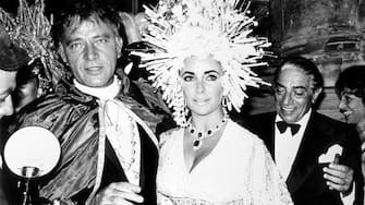 British-American actress Elizabeth Taylor (1932 - 2011), British actor Richard Burton (1925 - 1984) at 'Palazzo Rezzonico' for a masquerade party, Venice, Italy, 1967. Behind them, Greek shipping magnate Aristotle Onassis (1906 - 1975). (Photo by Archivio Cicconi/Getty Images)