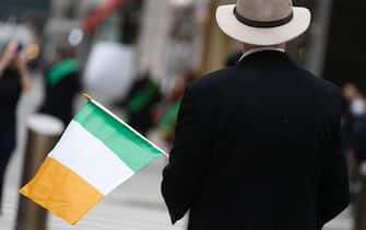 NEW YORK, NEW YORK - MARCH 17: A man holds an Irish Flag during St. Patricks Day on March 17, 2021 in New York City. Because of the ongoing coronavirus pandemic a socially distanced mass and a small procession to honor First Responders and Essential Workers was held as a mostly virtual parade that can be streamed by the public.   (Photo by John Lamparski/Getty Images)