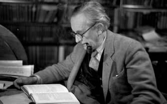 2nd December 1955:  John Ronald Reuel Tolkien (1892 - 1973), British writer and professor at Merton College Oxford, reading in his study. Original Publication: Picture Post - 8464 - Professor J R R Tolkien - unpub.  (Photo by Haywood Magee/Picture Post/Hulton Archive/Getty Images)