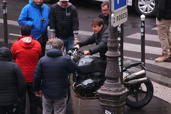 US actor Tom Cruise (R) sits on a motorcycle during the filming of "Mission Impossible 6" in a Paris street on May 3, 2017. / AFP PHOTO / STRINGER        (Photo credit should read STRINGER/AFP via Getty Images)