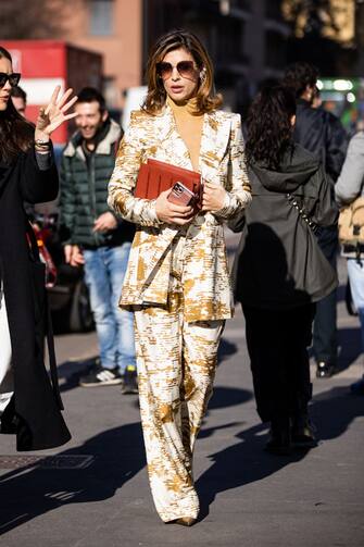 MILAN, ITALY - FEBRUARY 20: Elisabetta Canalis, wearing a gold top, white and gold printed suit and orange bag, is seen outside Max Mara show, during Milan Fashion Week Fall/Winter 2020-2021 on February 20, 2020 in Milan, Italy. (Photo by Claudio Lavenia/Getty Images)