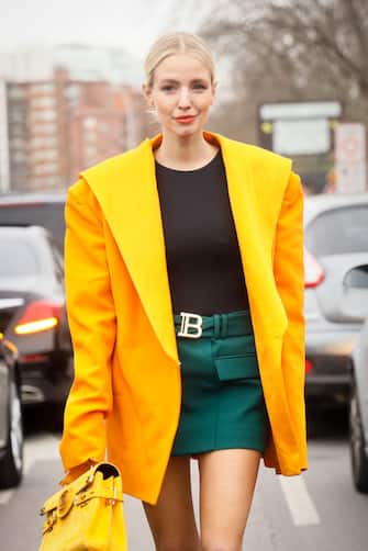PARIS, FRANCE - FEBRUARY 28: Leonie Hanne wearing yellow oversized jacket, green leather Balmain mini skirt, yellow Balmain leather bag outside the Balmain show during the Paris Fashion Week Womenswear Fall/Winter  on February 28, 2020 in Paris, France. (Photo by Hanna Lassen/Getty Images)
