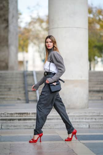 PARIS, FRANCE - NOVEMBER 06: Natalia Verza wears a gray wool turtleneck pullover with a white shirt part and long sleeves from Nehera, gray large wool pants from Nehera, a Prada belt, a Prada black leather bag, red high heeled Prada shoes, on November 06, 2020 in Paris, France. (Photo by Edward Berthelot/Getty Images)