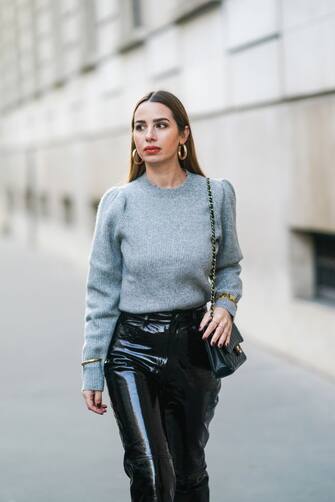 PARIS, FRANCE - DECEMBER 08: Maria Rosaria Rizzo wears golden earrings, a gray wool pullover from Tularosa, a black quilted Chanel bag, golden bracelets and jewelry, black shiny leather pants from LPA, a Chanel bag, on December 08, 2020 in Paris, France. (Photo by Edward Berthelot/Getty Images)