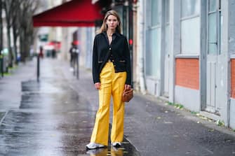 PARIS, FRANCE - DECEMBER 04: Natalia Verza aka "Mascarada Paris" wears a black shirt, a black wool cardigan, a brown leather geometric Loewe bag, yellow monogram printed Gucci flared pants, sneakers shoes from New Balance, a golden necklace, on December 04, 2020 in Paris, France. (Photo by Edward Berthelot/Getty Images)