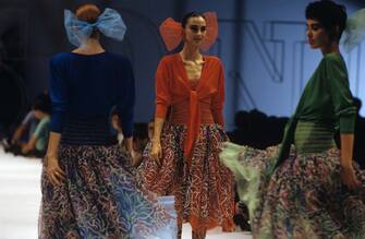 "Three models walk down the catwalk with dresses by Missoni, respectively in the blue, red and green colours, showing off in their hair a ribbon of the same colour. Milan (Italy), 1986.  (Photo by Nino Leto\Mondadori via Getty Images)"