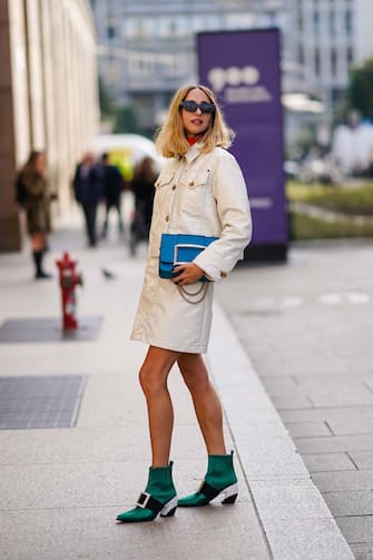 MILAN, ITALY - FEBRUARY 20: candela Novembre wears sunglasses, a white jacket dress, a blue bejeweled bag, green pointy shoes, outside Vivetta, during Milan Fashion Week Fall/Winter 2020-2021 on February 20, 2020 in Milan, Italy. (Photo by Edward Berthelot/Getty Images)