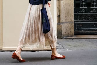 PARIS, FRANCE - JUNE 20: A passerby wears a pale pink pleated skirt with embroidery, brown flat shoes, a blue bag, on June 20, 2020 in Paris, France. (Photo by Edward Berthelot/Getty Images)