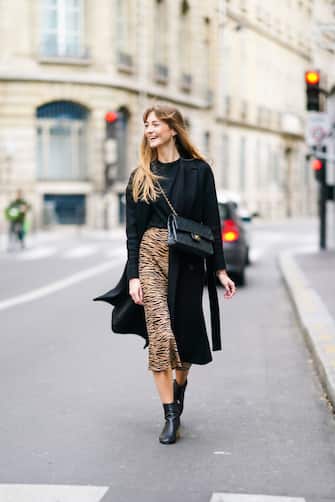PARIS, FRANCE - OCTOBER 04: Bertille Canat wears a black wool long coat, a black pullover, a black quilted Chanel bag, a brown and black zebra pattern printed skirt, black leather boots, outside the unveilling of the Longchamp collection Spring/Summer 2021, during Paris Fashion Week - Womenswear Spring Summer 2021, on October 04, 2020 in Paris, France. (Photo by Edward Berthelot/Getty Images)