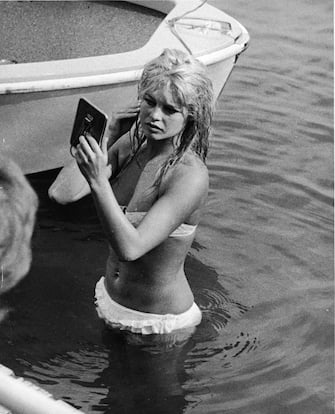 French actor Brigitte Bardot looks at her reflection in a mirror, while standing in the waters of Lake Leman, June 13, 1961. (Photo by Express Newspapers/Getty Images)