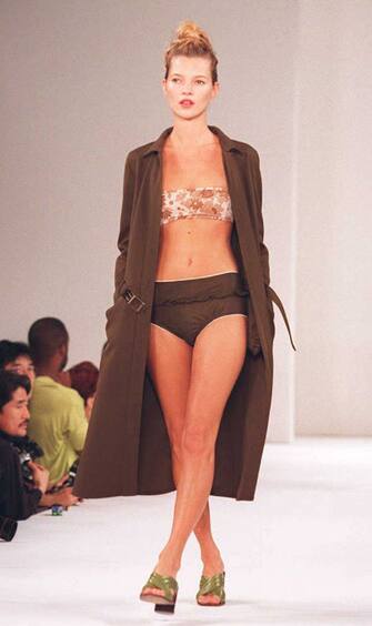 NEW YORK, NY - NOVEMBER 2:  Supermodel  Kate Moss wears a brown swimsuit with a flowered top and a long coat during the Miu Miu Spring/Summer 1996 fashion show 02 November in New York.  (Photo credit should read TIMOTHY CLARY/AFP via Getty Images)