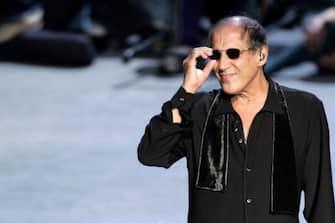 Milan, ITALY:  Italiqn rockstar and actor Adriano Celentano, hoster of National Television Channel  satirical programme 'Rockpolitick'' 's during his perforlance on show  27 October 2005 at the outskirts of Milan.  Guest star of  the show, Oscar wining Roberto Benign  set  avery high TV watcher' s share last night, with more than 12 Thousand spectators watching the programme on Rai Uno.  AFP PHOTO / Filippo MONTEFORTE  (Photo credit should read FILIPPO MONTEFORTE/AFP via Getty Images)