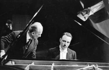 26th June 1959:  Italian pianist Arturo Benedetti Michelangeli (1920 - 1995), (right), and his tuner Ettore Tallone at the piano during a concert tour.  (Photo by Erich Auerbach/Getty Images)
