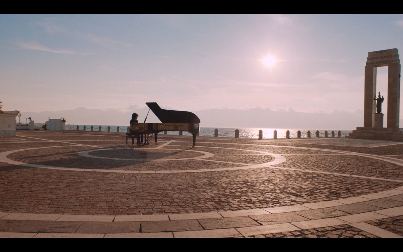Giovanni Allevi è seduto al pianoforte e si lascia ispirare dal suono del mare