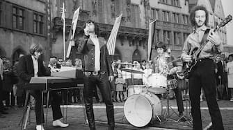 (Original Caption) This is a photo of the American rock group, "The Doors," performing outside of Town Hall in Frankfurt. Left to right are organist Ray Manzarrek; lead singer Jim Morrison; drummer John Densmore; and guitarist Robby Krieger.