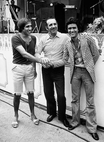 The Italian singer Giovanni Nazzaro (known as Gianni Nazzaro) at the final day of the Italian music festival Cantagiro 1972: with him the Italian singer and actor Adriano Celentano (with short pants) and the organizer and father of the festival Ezio Radaelli. Recoaro Terme (VI), Italy, 1972.. (Photo by Mondadori via Getty Images)