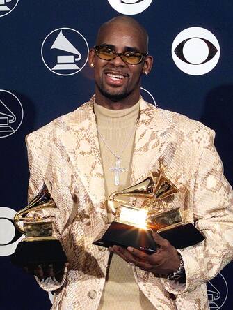 NEW YORK, UNITED STATES:  R. Kelly holds his three Grammy Awards 25 February in New York at the 40th annual Grammy Awards. Kelly won Grammys for his record "I Believe I Can Fly."    (Electronic Image)   AFP PHOTO    Matt CAMPBELL (Photo credit should read MATT CAMPBELL/AFP via Getty Images)