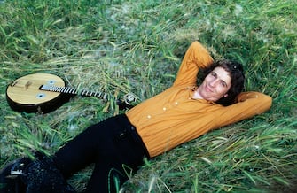 Singer-songwriter Rino Gaetano lying on grass next to a chordophone musical instrument. Italy, 1978 (Photo by Angelo Deligio\Mondadori Portfolio\Mondadori via Getty Images)