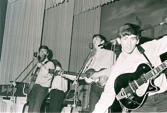 GERMANY - MAY 01:  Photo of (L-R) singer-guitarist John Lennon, singer-bassist Paul McCartney and guitarist George Harrison of The Beatles, live onstage circa May 1962 at the Star-Club in Hamburg, Germany. (Photo by K & K Ulf Kruger OHG/Redferns)