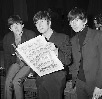 Paul McCartney, John Lennon and George Harrison of The Beatles with a copy of the Southend-on-Sea and County Pictorial during a press conference at the Southend Odeon Cinema, 9th December 1963. (Photo by Mark and Colleen Hayward / Getty Images)