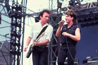 Rock musicians the Edge (born David Evans) (left) and Bono (born Paul Hewson), both of the group U2, perform onstage during the US Festival, Ontario, California, May 30, 1983. (Photo by Paul Natkin/Getty Images)