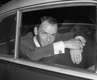 Hollywood singer, Frank Sinatra, looks quizically into a press camera shortly after a conference with the Rome press where he denied reports that he had been booed and ca-called off the stage of a Naples theater. The incident supposedly occured when Sinatra's wife, actress Ava Gardner, billed to appear with him, failed to keep the engagement. According to press reports, the disappointed fans protested violently and walked out on the Sinatra performance.