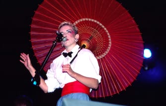 Scottish musician Annie Lennox, of the group Eurythmics, holds a parasol as she performs onstage at Forest Hills Stadium, Forest Hills, New York, August 3, 1984. (Photo by Gary Gershoff/Getty Images)