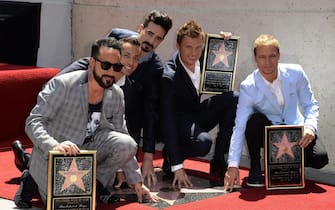 epa03673225 US band Backstreet Boys touch their star during a ceremony honoring them on the Hollywood Walk of Fame in Hollywood, California, USA, 22 April 2013.  The Backstreet Boys are a multi-platinum pop group that started 20 years ago and have sold more than 130 million albums worldwide. From L to right are:  AJ McLean, Howie Dorough, Kevin Richardson, Nick Carter and Brian Littrell.  EPA/MICHAEL NELSON