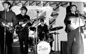 LONDON - MARCH 22: Rock and roll band "The Beatles" perform in record shop to promote the release of their album "Please Please Me" on March 22, 1963 in London, England. (L-R) Paul McCartney, George Harrison, Ringo Starr, John Lennon. (Photo by Michael Ochs Archives/Getty Images) 
