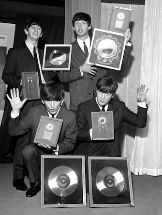 The Beatles, pictured at EMI House Manchester Square, London, with a hoard of silver discs. They were presented with two silver LPs to mark the quarter-million plus sales of their first LP "Please Please Me" and their new one "With the Beatles" as well as for their "Twist & Shout" EP and "She Loves You". Left to right: Ringo Starr, George Harrison, Paul McCartney and John Lennon.   (Photo by PA Images via Getty Images)
