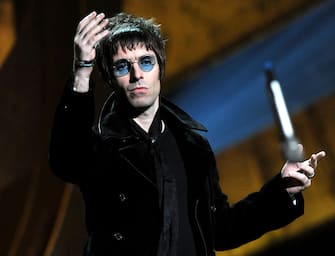LONDON, ENGLAND - FEBRUARY 16:  Liam Gallagher throws his microphone into the audience after accepting Oasis' award for 'Best Album of 30 Years' on stage at The Brit Awards 2010 at Earls Court on February 16, 2010 in London, England.  (Photo by Gareth Cattermole/Getty Images)