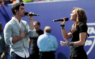 epa02305237 Singers Joe Jonas (L), of the Jonas Brothers, and Demi Lovato (R) perform during Arthur Ashe Kids Day at the USTA Billie Jean King National Tennis Center in Flushing Meadows, New York, USA, on 28 August 2010. The 2010 US Open tennis tournament begins on Monday 30 August.  EPA/JUSTIN LANE