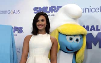 epa05856448 US singer/actress Demi Lovato smiles in front of Smurfette at the International Day of Happiness in conjunction with 'Smurfs: The Lost Village' at United Nations headquarters in New York, New York, USA, 18 March 2017. Lovato is the dubbing voice of the character 'Smurfette' in the upcoming movie 'Smurfs: The Lost Village'.  EPA/JASON SZENES