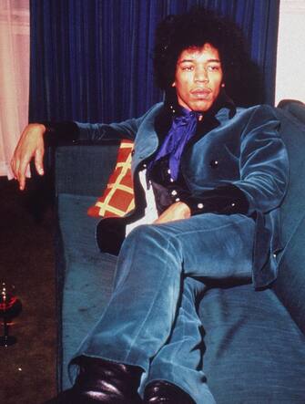 1967:  American rock musician Jimi Hendrix (1942 - 1970) wears a teal velvet suit while reclining on a sofa.  (Photo by Hulton Archive/Getty Images)