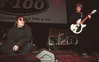 PHILADELPHIA - DECEMBER 3: Singer Liam Gallagher (L) and brother Noel Gallagher from Oasis on stage on December 3, 1999 in Philadelphia. (Photo by Dave Hogan/Getty Images)