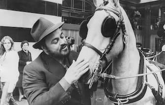 Italian opera singer Luciano Pavarotti calming the horse before taking a horse and carriage ride from his hotel to Liberty's, outside the Savoy Hotel in London, May 14th 1981. (Photo by Graham Turner/Keystone/Getty Images)