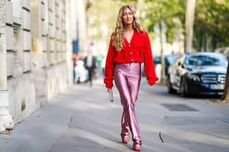 PARIS, FRANCE - SEPTEMBER 27: Emili Sindlev wears earrings, a red wool V-neck top, lustrous pink full-length pants, red heels with a bejeweled buckle, a glittering bejeweled clutch , outside Alessandra Rich, during Paris Fashion Week - Womenswear Spring Summer 2020 on September 27, 2019 in Paris, France. (Photo by Edward Berthelot/Getty Images)