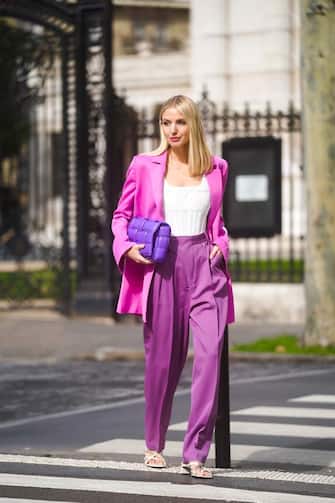 PARIS, FRANCE - MARCH 03: Leonie Hanne wears a neon pink oversized blazer jacket, a white low neck top, a purple Bottega Veneta quilted bag, purple flared pants, white shoes, during Paris Fashion Week - Womenswear Fall/Winter 2020/2021 on March 03, 2020 in Paris, France. (Photo by Edward Berthelot/Getty Images)