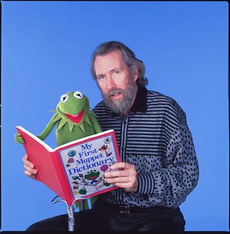Portrait of American puppeteer and film & television director Jim Henson (1936 - 1990) as he poses with one of his creations, Kermit the Frog, New York, New York, January 4, 1988. Henson holds open a copy of the book, 'My First Muppet Dictionary.' (Photo by Michel Delsol/Getty Images)
