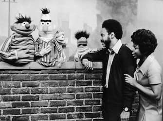Matt Robinson (1937 - 2002) (as Gordon) and Loretta Long (as Susan) lean on a brick wall and speak with, from left, Muppets Ernie, Bert, an Anything Muppet, and Roosevelt Franklin, October 15, 1970. (Photo by Children's Television Workshop/Courtesy of Getty Images)