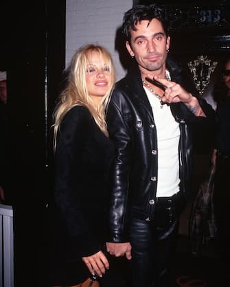 Motley Crue drummer Tommy Lee makes the peace sign while standing with his wife, actress Pamela Anderson Lee.   (Photo by Mitchell Gerber/Corbis/VCG via Getty Images)