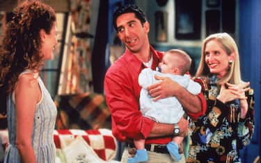 American actor David Schwimmer holds a baby, as actors Jessica Hecht (L) and Jane Sibbett look on, in a still from the television series, 'Friends,' circa 1995. (Photo by Fotos International/Getty Images)