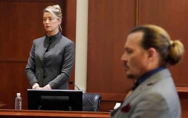TOPSHOT - American actors Amber Heard (L) and Johnny Depp watch jurors leave the courtroom at the end of the day at the Fairfax County District Courthouse in Fairfax, Virginia, May 16, 2022.  — American actor Johnny Depp is suing his ex-wife Amber Heard for libel in Fairfax County District Court after she wrote an op-ed in The Washington Post in 2018 identifying herself "public figure representing domestic violence." (Photo by Steve Helber/POOL/AFP) (Photo by STEVE HELBER/POOL/AFP via Getty Images)