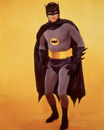 circa 1966:  American actor Adam West poses in costume as Batman in front of a yellow backdrop in a promotional portrait for the television series, 'Batman'.  (Photo by Hulton Archive/Getty Images)