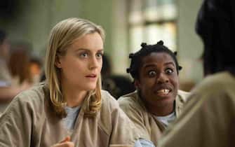 This image released by Netflix shows Taylor Schilling, left, and Uzo Aduba in a scene from "Orange is the New Black."  Revealing secret endings and plot twists has brought on wrath since the dawn of cinema, straight through VCRS to streaming and DVRs. Does the 13-episode Netflix dump of "Orange is the New Black" in July equal two months of polite spoiler-free behavior?  (AP Photo/Netflix, Paul Schiraldi)