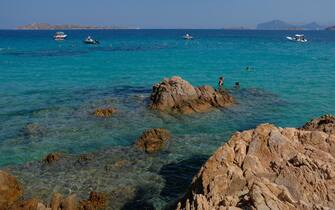 PORTO CERVO, ITALY - JULY 27:  Visitors relax in turquoise water at Spiaggia del Principe beach on the Costa Smeralda on July 27, 2018 on the island of Sardinia near Porto Cuervo, Italy. Sardinia is a popular summer tourist destination.  (Photo by Sean Gallup/Getty Images)