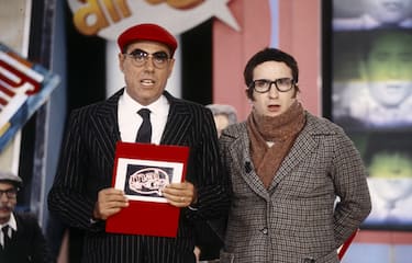 Italian comedian Teo Teocoli, in the guise of AC Milan supporter Peo Pericoli, one of his most famous characters, conducting the program Mai dire Gol; at his side Antonio Albanese, one of the main actors collaborating in the broadcast, assists him playing the comic role of Epifanio; at their backs are Giovanni Storti, seated, and Giacomo Poretti, standing, two memberso of the comic trio Aldo Giovanni & Giacomo on 1994 in Cologno Monzese (MI), Italy.