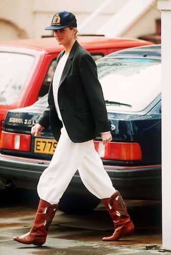 Princess Diana wearing an unusual combination of white trousers, boots, a blazer jacket and a baseball cap after taking her sons to school at Wetherby, 25th April 1989.  (Photo by Daily Mirror/Mirrorpix/Getty Images)