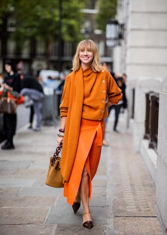 LONDON, ENGLAND - SEPTEMBER 15: Lisa Aiken wearing orange knit and skirt with slit and bag, heels is seen outside ALEXACHUNG during London Fashion Week September 2018 on September 15, 2018 in London, England.  (Photo by Christian Vierig/Getty Images)